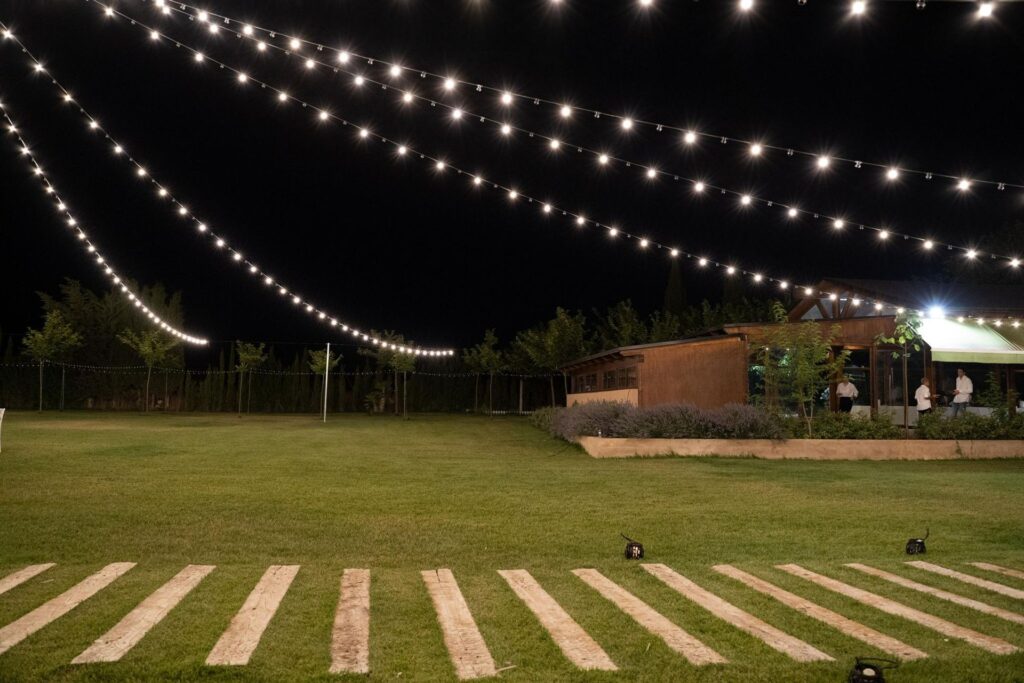 Explanada de Finca La Huerta iluminada de noche con guirnaldas de luces